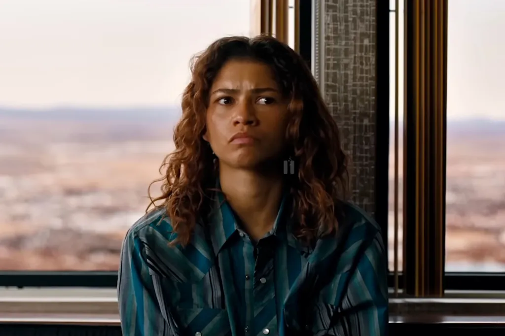 Zendaya in a blue-striped button-up shirt with a concerned expression.
