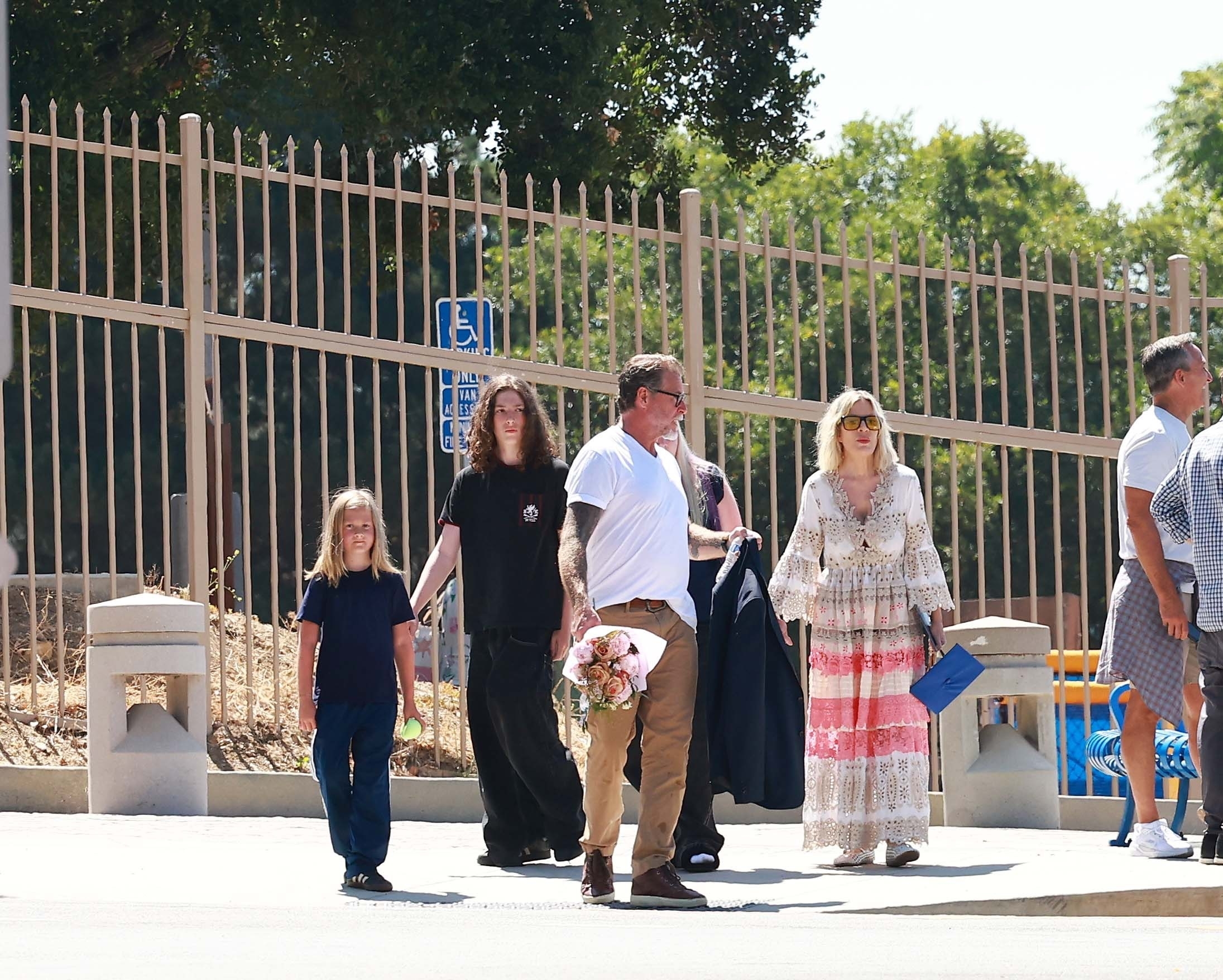 Tori Spelling and Dean McDermott leaving their daughter's graduation ceremony with their children.