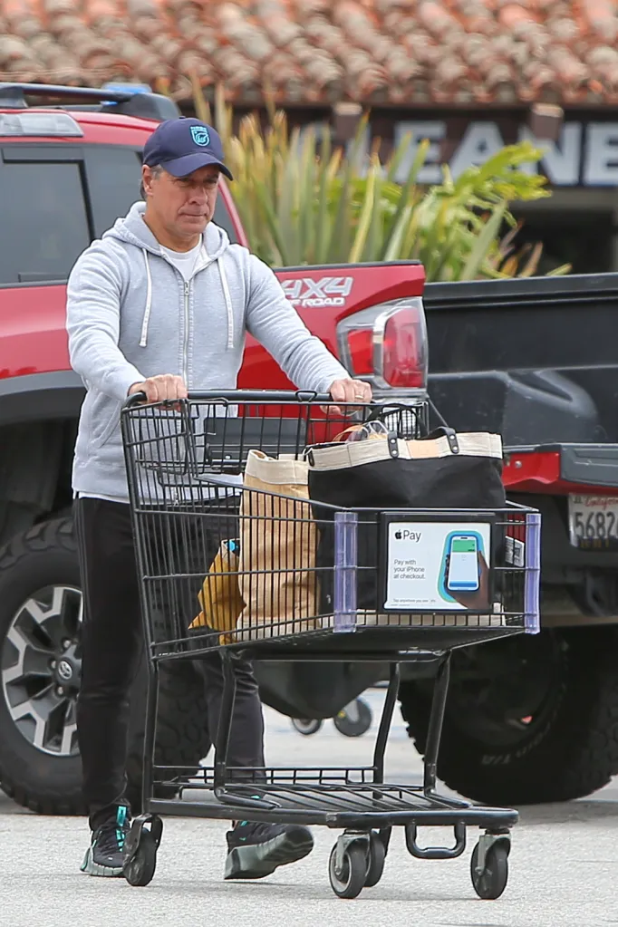Alberto Carvalho pushing a shopping cart in a parking lot.