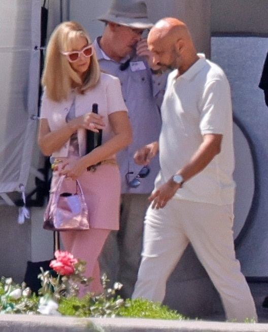 Lisa Kudrow in character as Romy, wearing a pink outfit and sunglasses, with Keegan-Michael Key on the set of the 'Romy and Michelle' sequel.