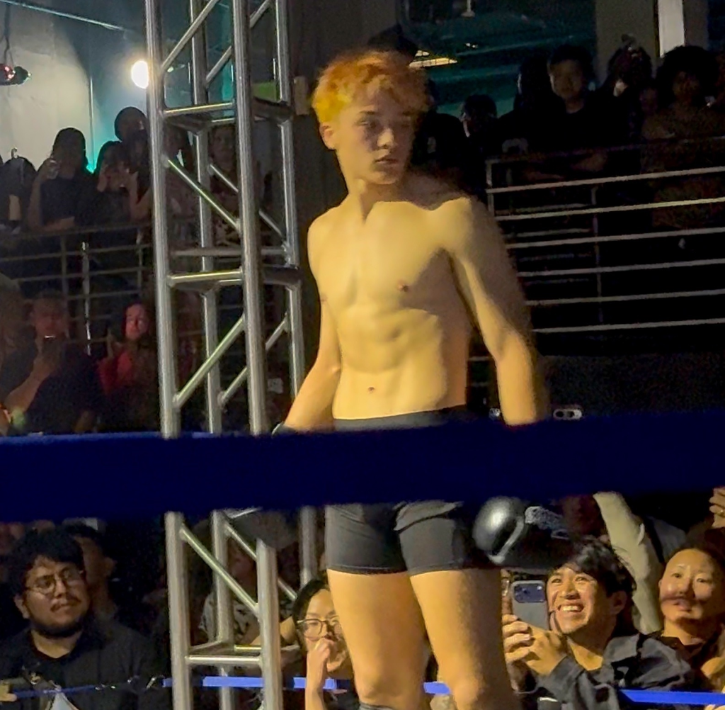 Knox Jolie-Pitt in a boxing ring during an exhibition fight.