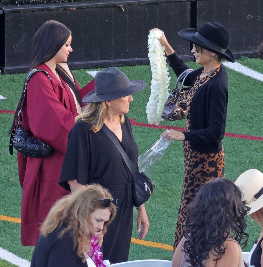 Kate Richie Madden in a maroon graduation gown next to Nicole Richie in a leopard print dress, both wearing hats, and Brenda Richie in a black dress, at Kate's graduation.