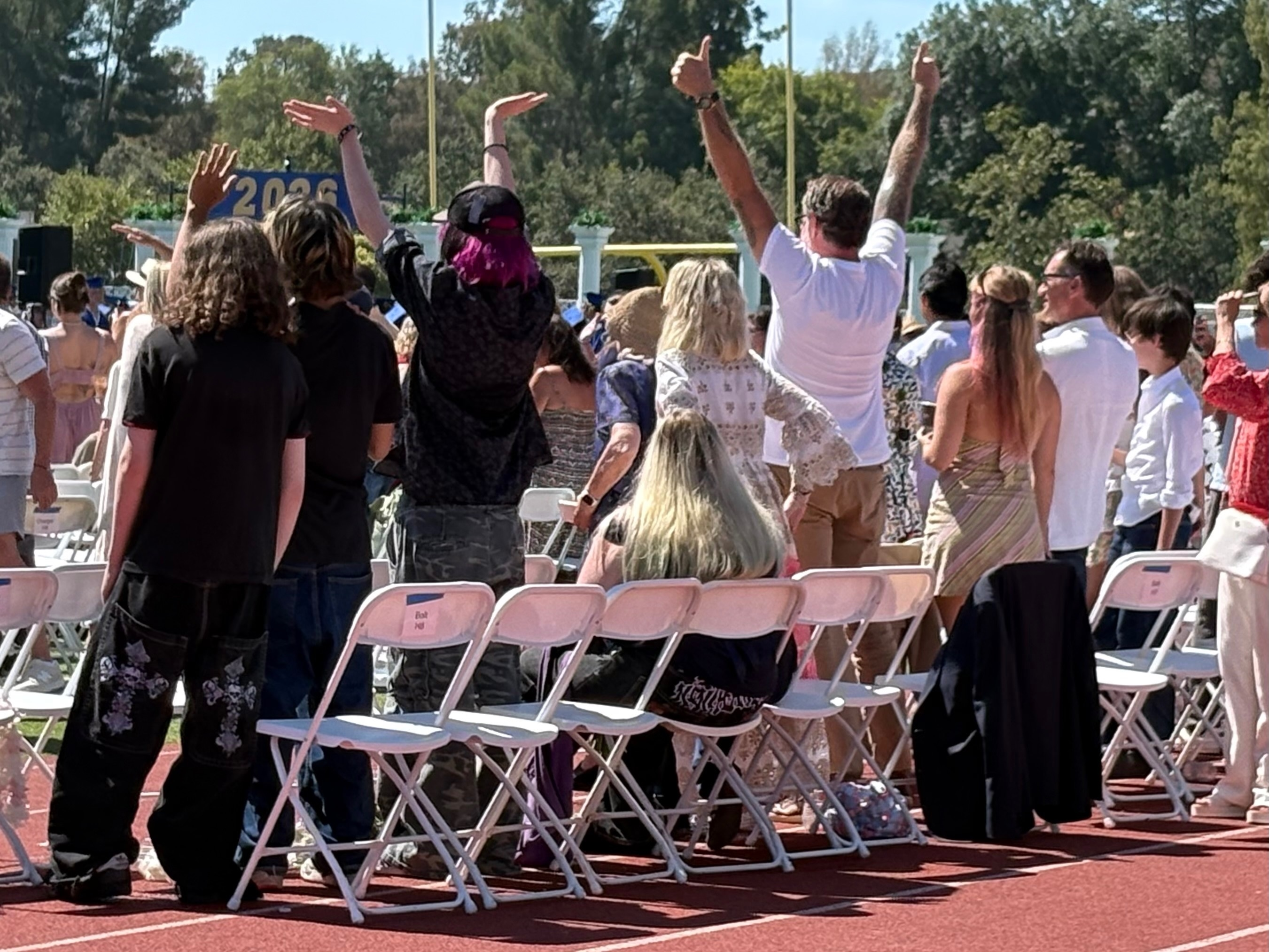 Tori Spelling and Dean McDermott cheering on their daughter at her graduation.