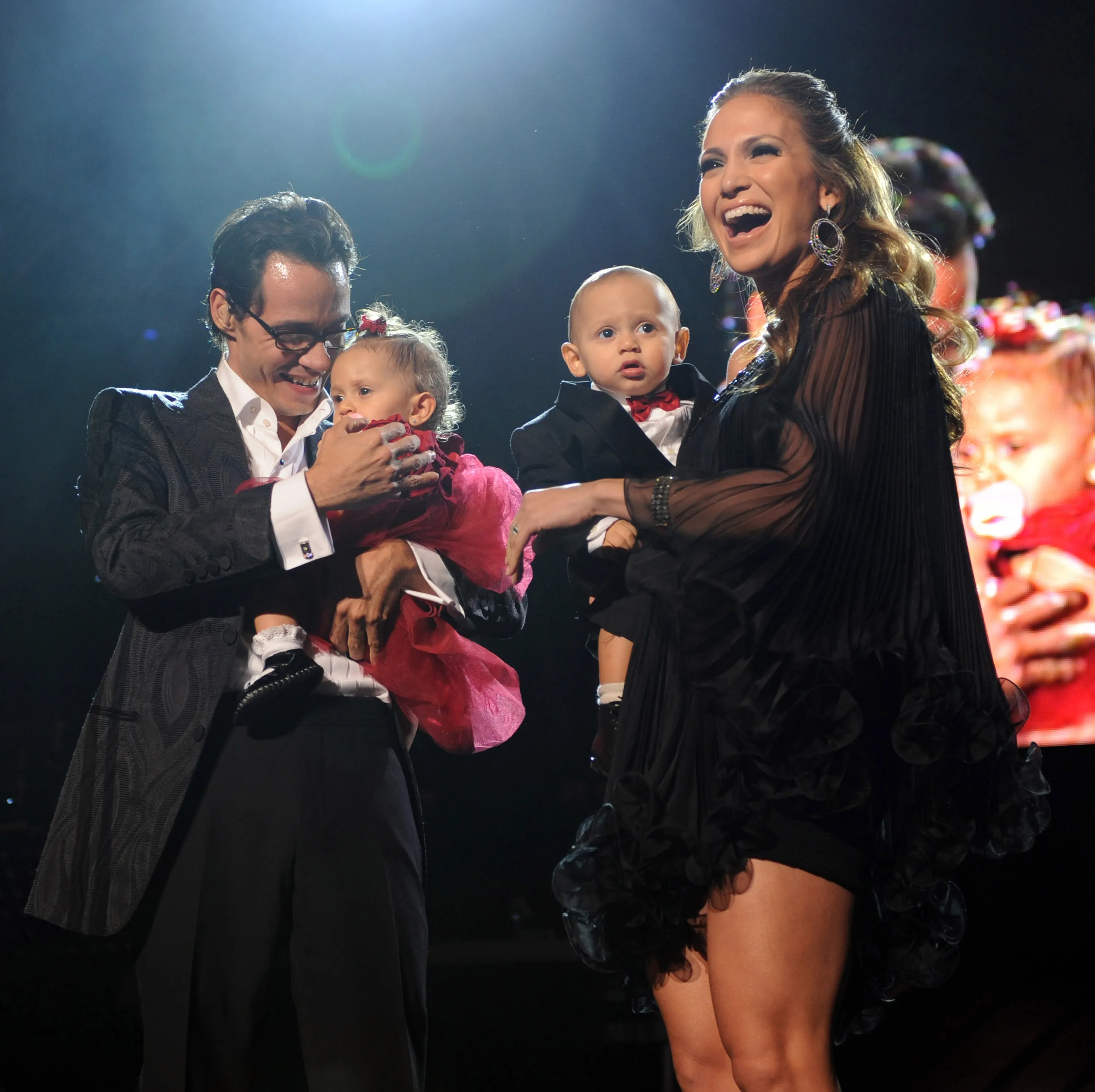 Marc Anthony and Jennifer Lopez with their babies Max and Emme on stage.