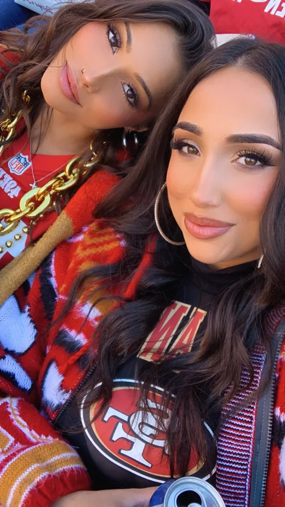 Two young women wearing 49ers gear.