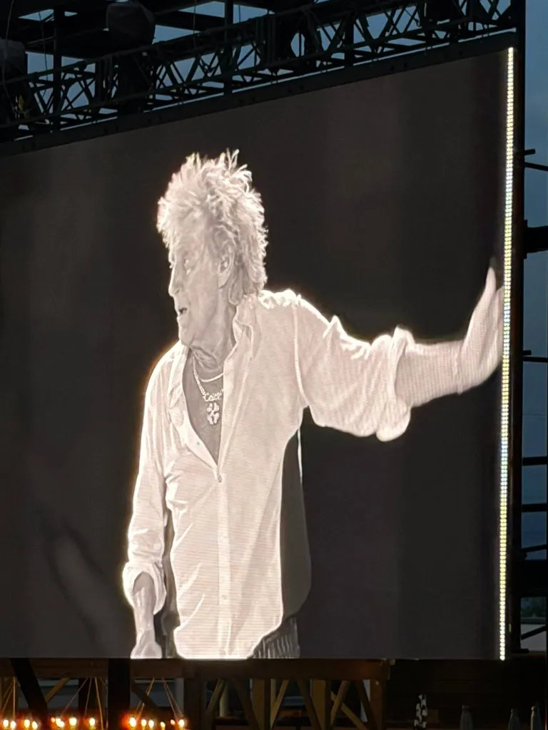 Rod Stewart on a large screen during a concert.