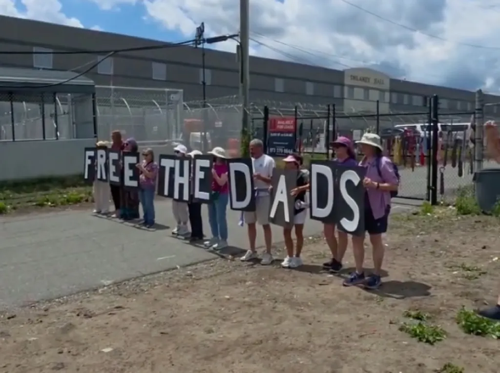 Protesters holding signs spelling 