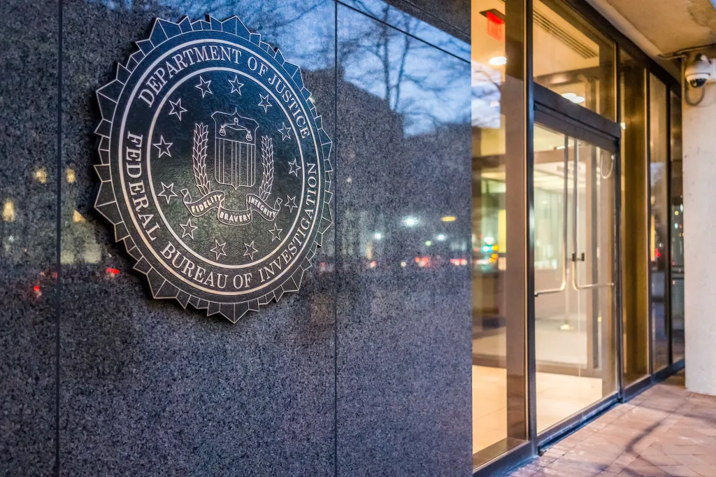 The FBI seal on the side of the Federal Bureau of Investigation Headquarters in Washington D.C. at night.