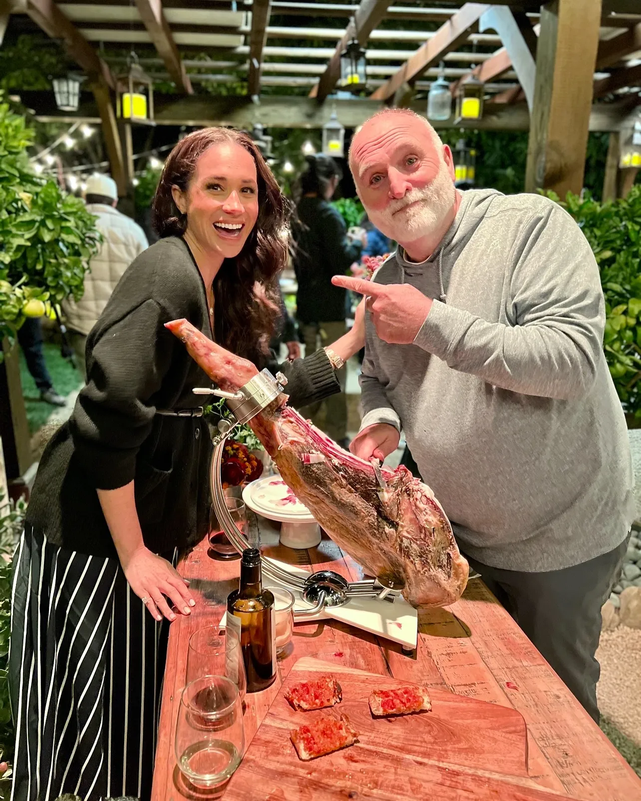 Meghan Markle and Jose Andres pose next to a leg of jamón.