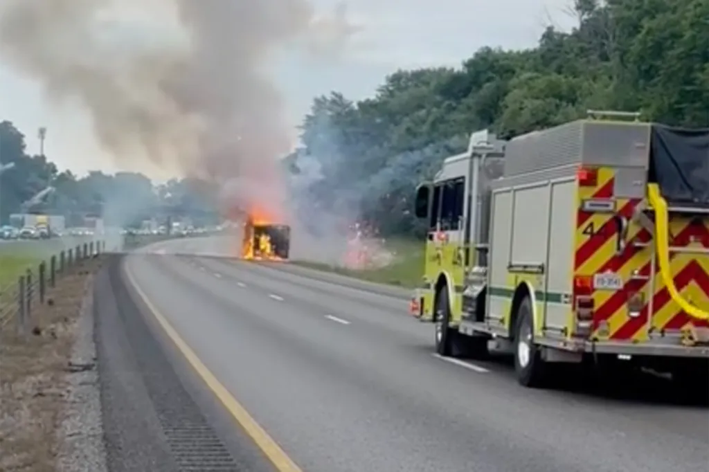 A fire truck on a highway responding to a fire and fireworks coming from a vehicle on the shoulder of the road.