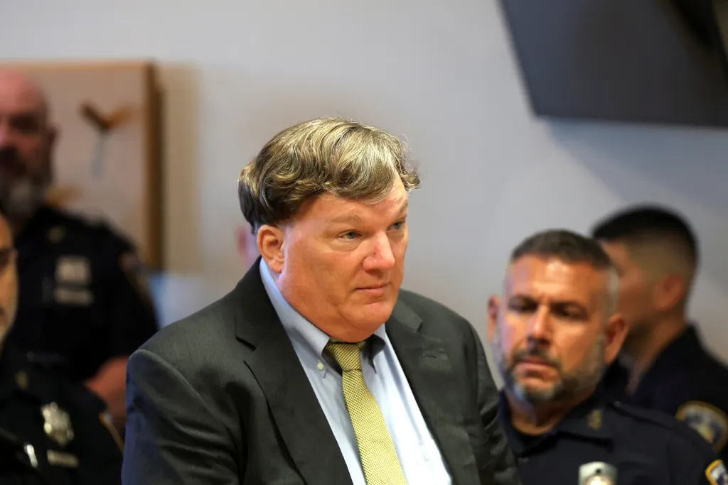 Rex Heuermann in court during his sentencing, with officers in the background.