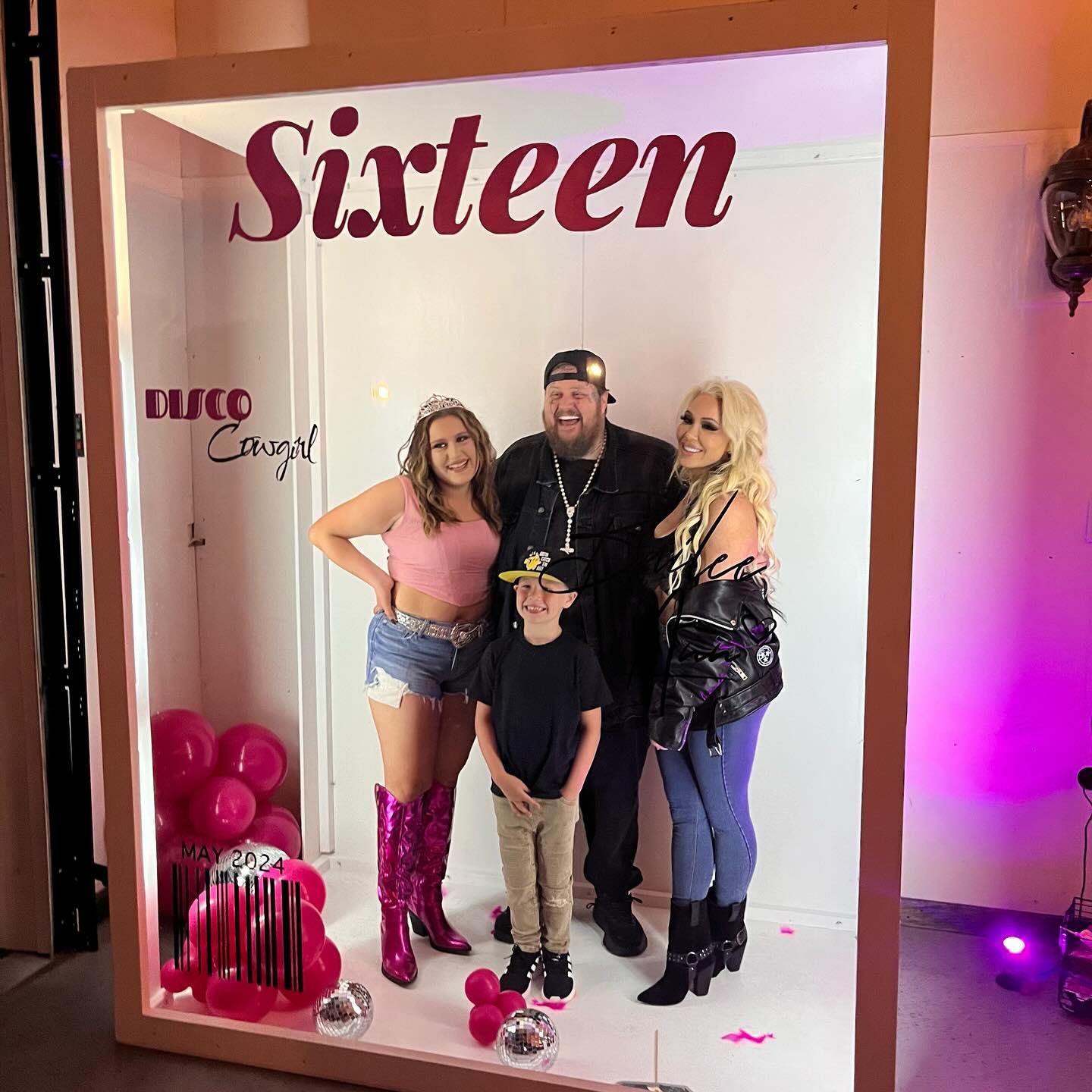 Bailee Ann, Jelly Roll, Bunnie XO, and a child pose in a photo booth with 