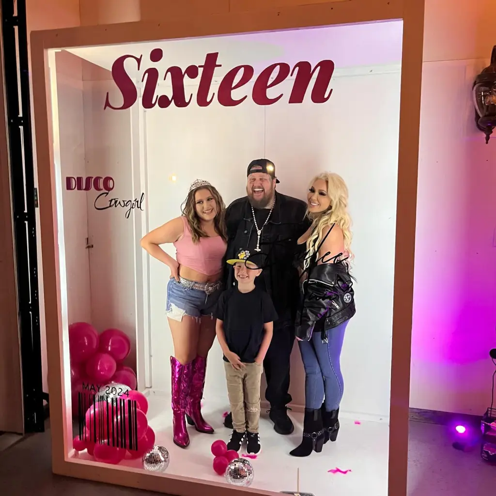 Jelly Roll, Bunnie Xo, Bailee Ann, and a young boy pose inside a 