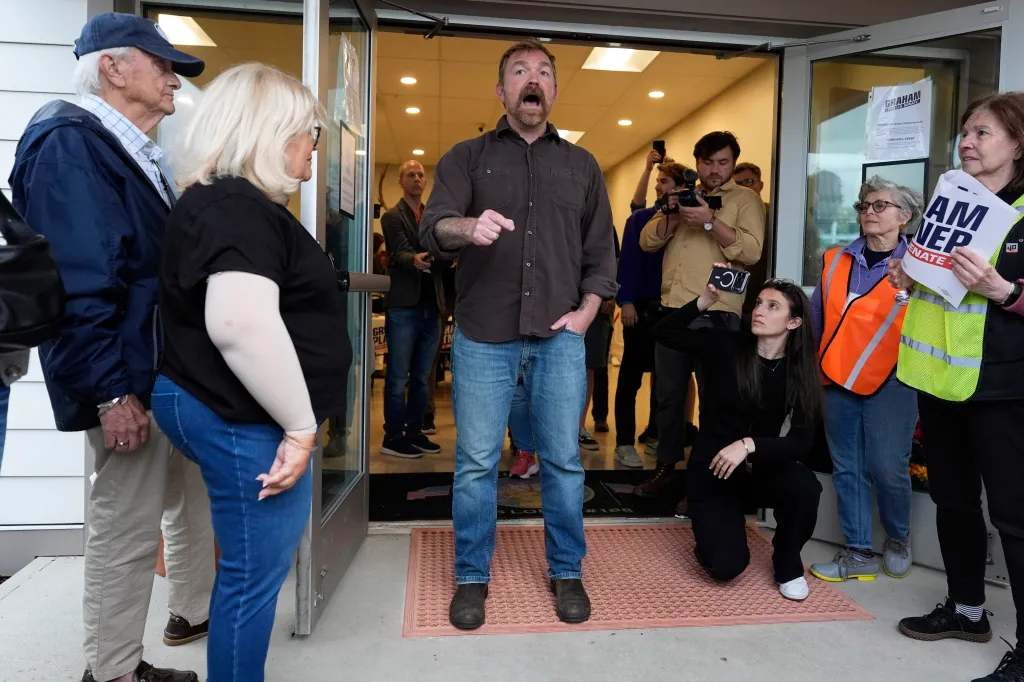 Graham Platner speaks to an overflow crowd outside a campaign event.