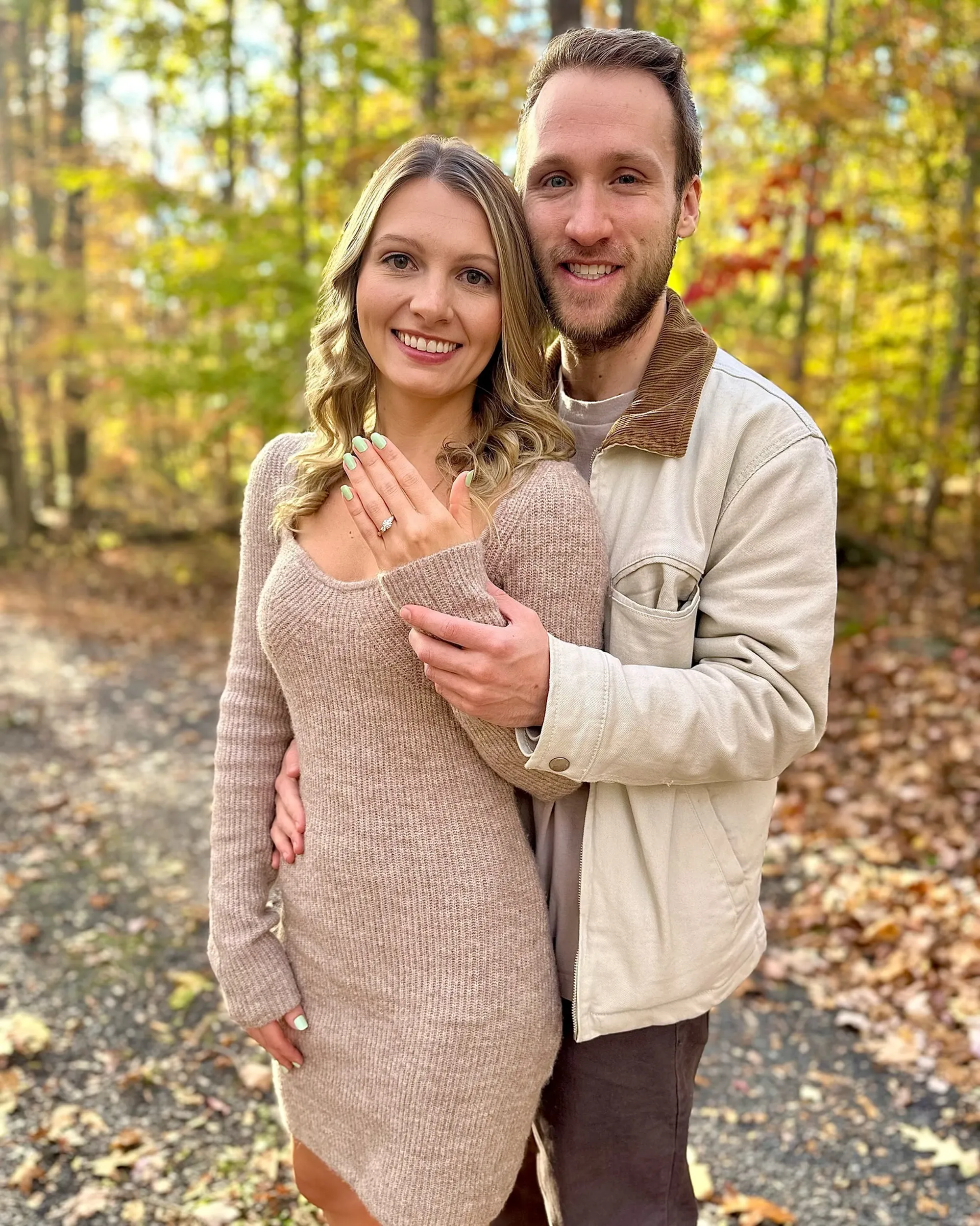 Jesse Ridgway and his wife smiling for a photo, the woman showing off an engagement ring.