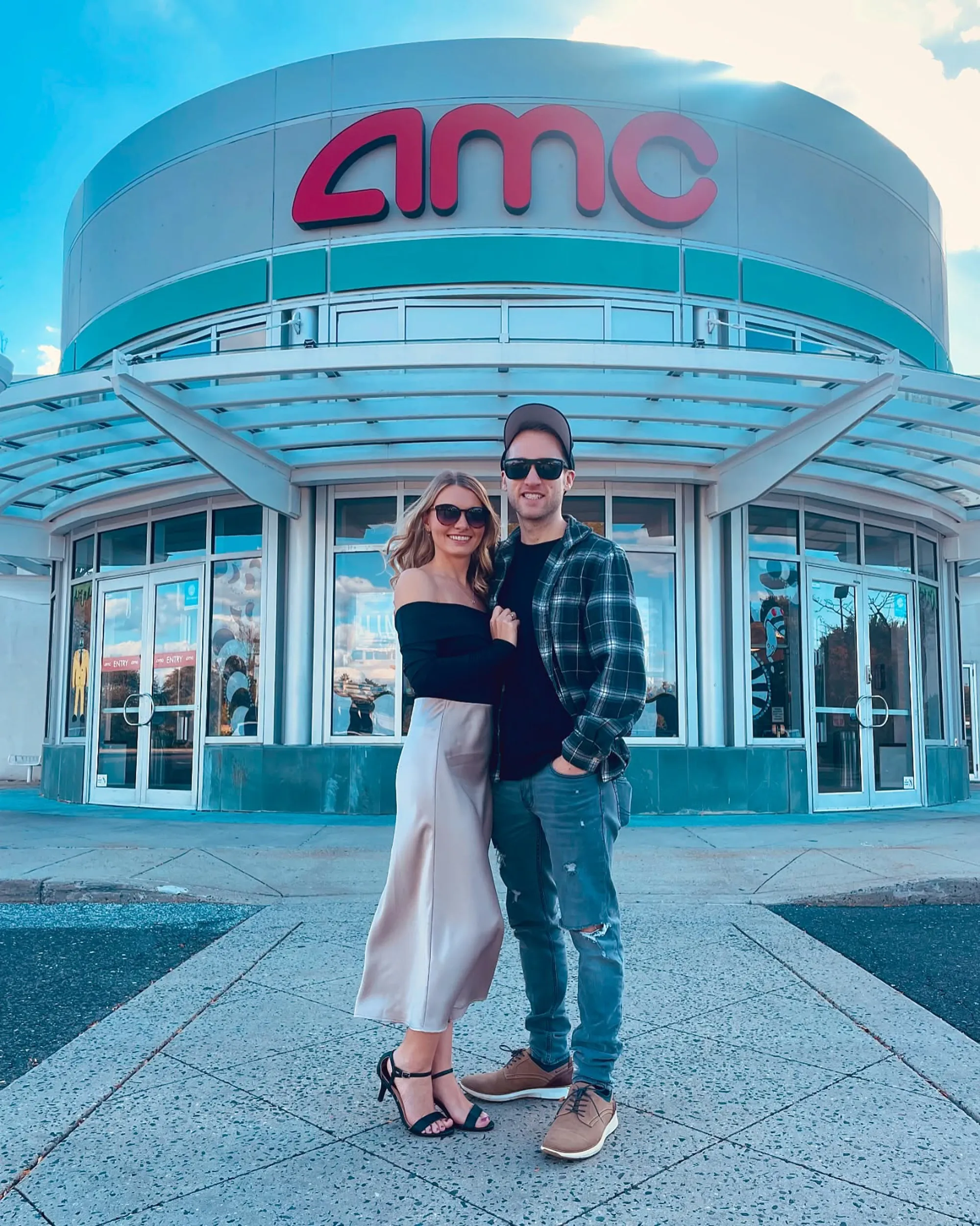 Jesse Ridgway and his wife standing in front of an AMC movie theater.