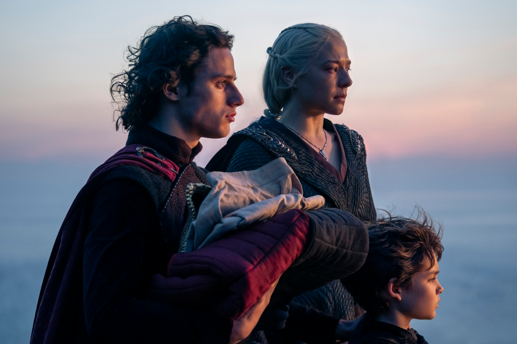 Harry Collett and two other actors from House of the Dragon Season 2 looking out over a sunset-lit horizon.