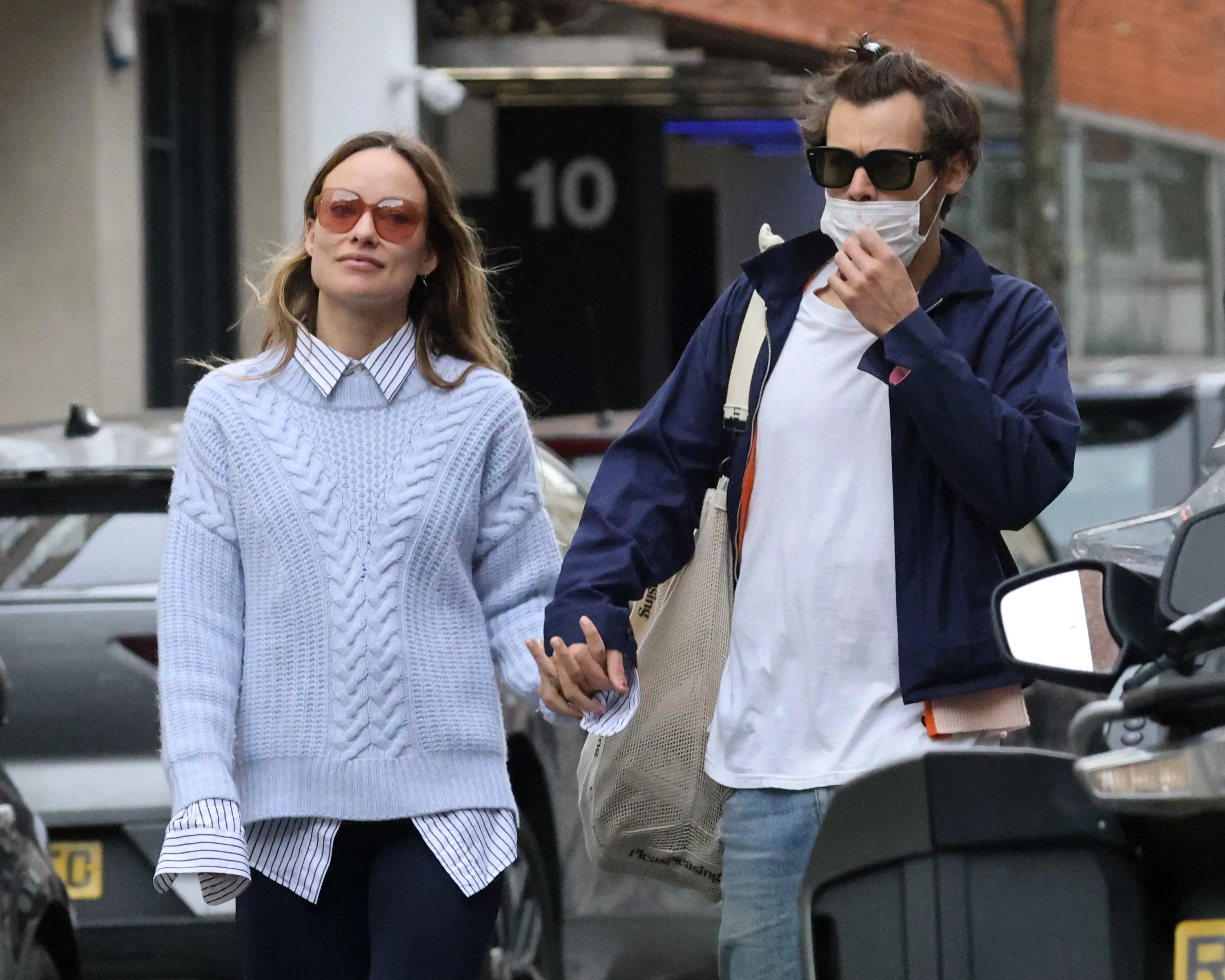 Olivia Wilde and Harry Styles holding hands while walking in London.