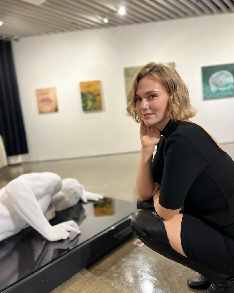 A picture of Helphenstein posing next to a sculpture. 
