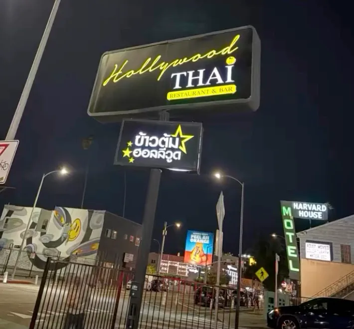 A night photo of the glowing sign for Hollywood Thai Restaurant & Bar.
