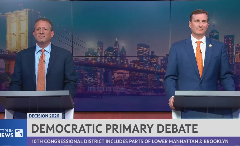 Dan Goldman and Brad Lander debating at podiums in front of a New York City skyline.