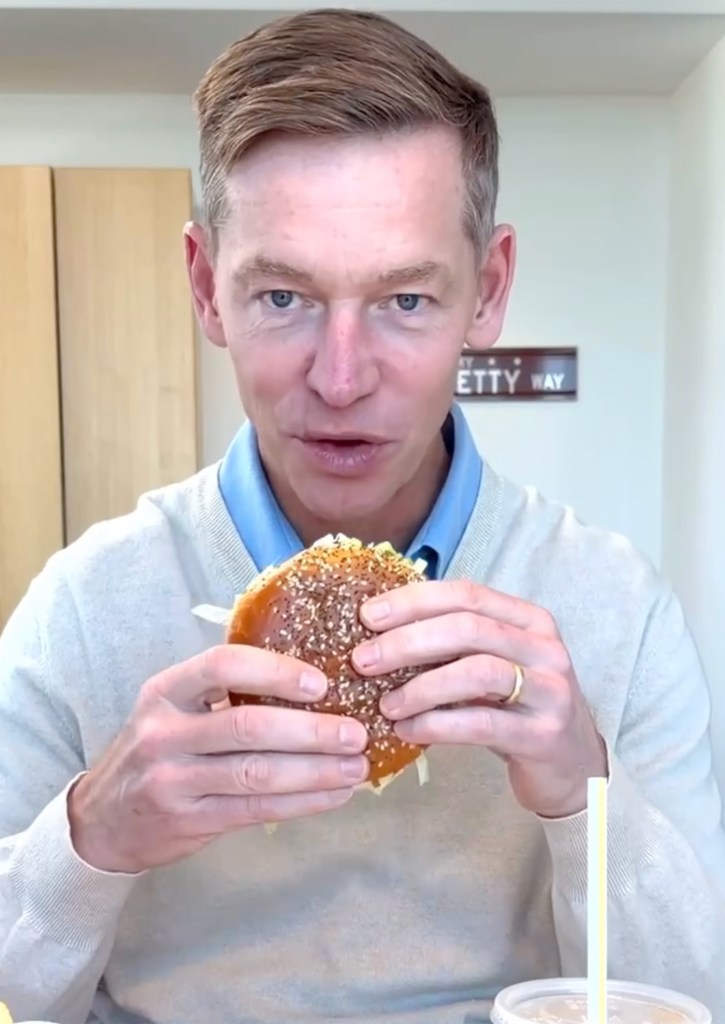 McDonald's CEO Chris Kempczinski holding a Big Arch sandwich.