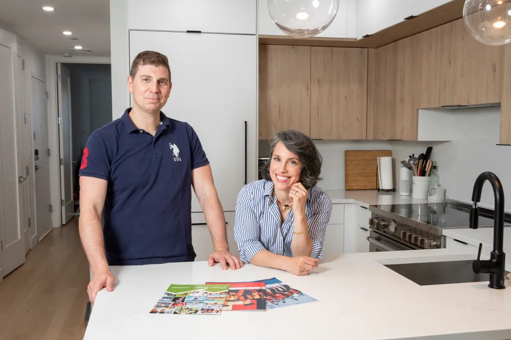Jeff and Maddy Novich with Swiss summer camp brochures in their Harlem kitchen.