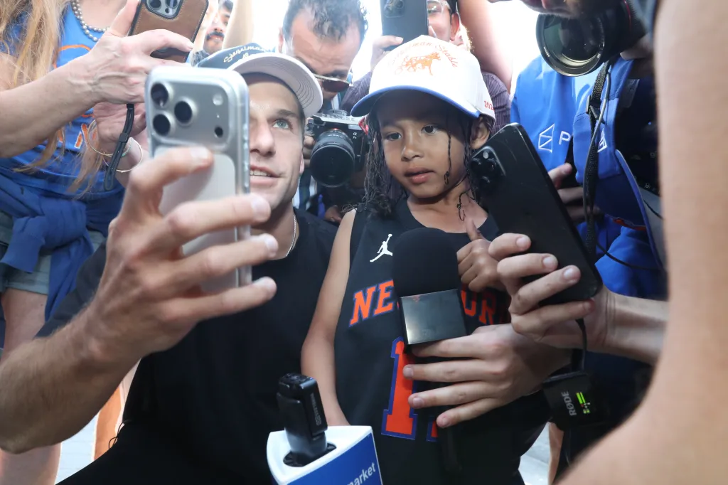 A man in a white cap takes a selfie with 5-year-old Francisco, winner of the Jalen Brunson lookalike contest.