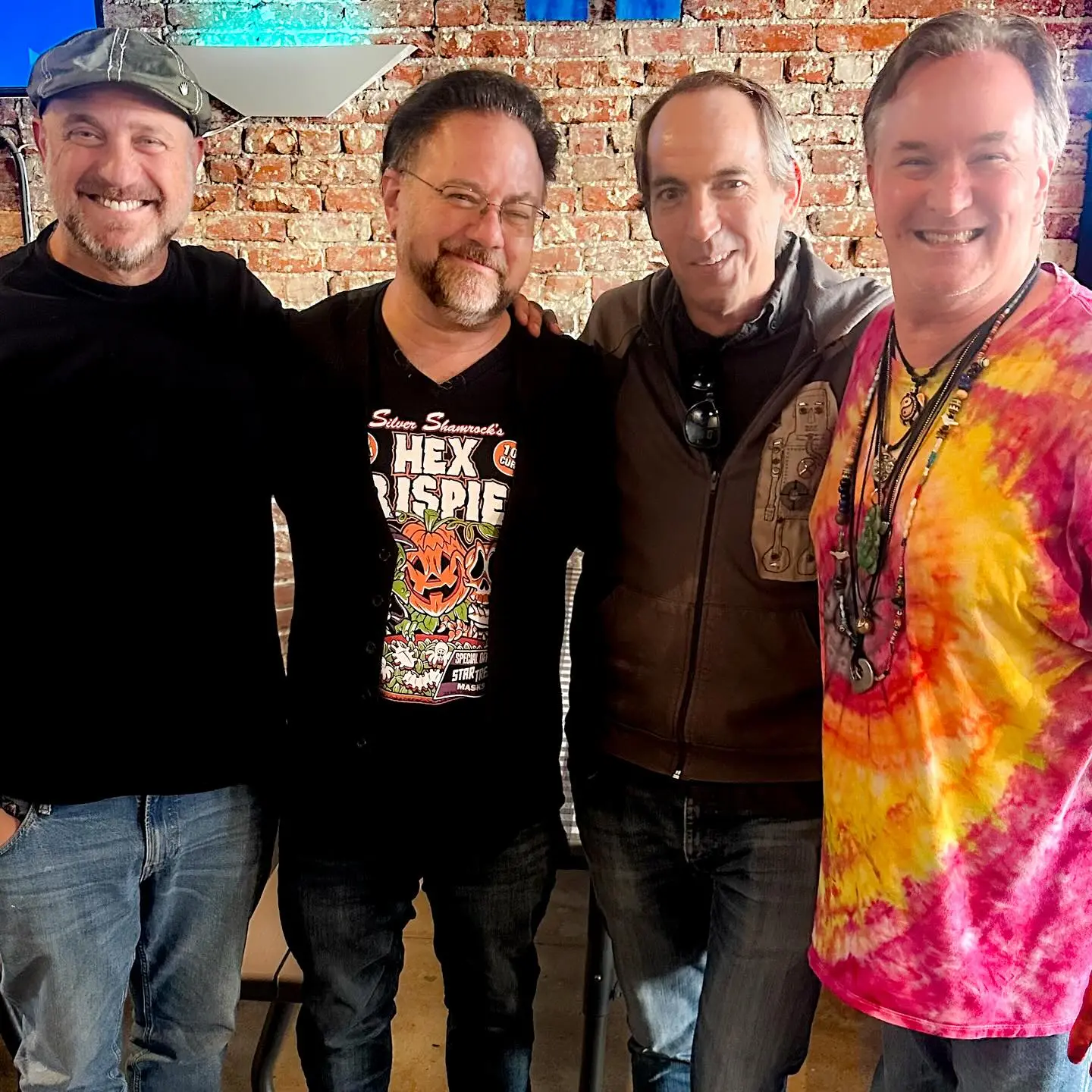 Four men smiling, standing next to each other.