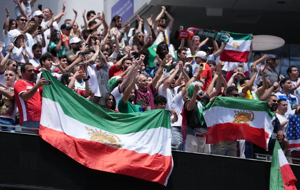 Iran fans celebrating with flags after a match.