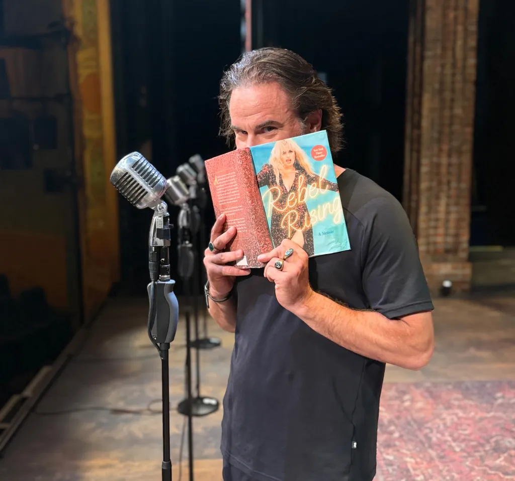 A man holding Rebel Wilson's book