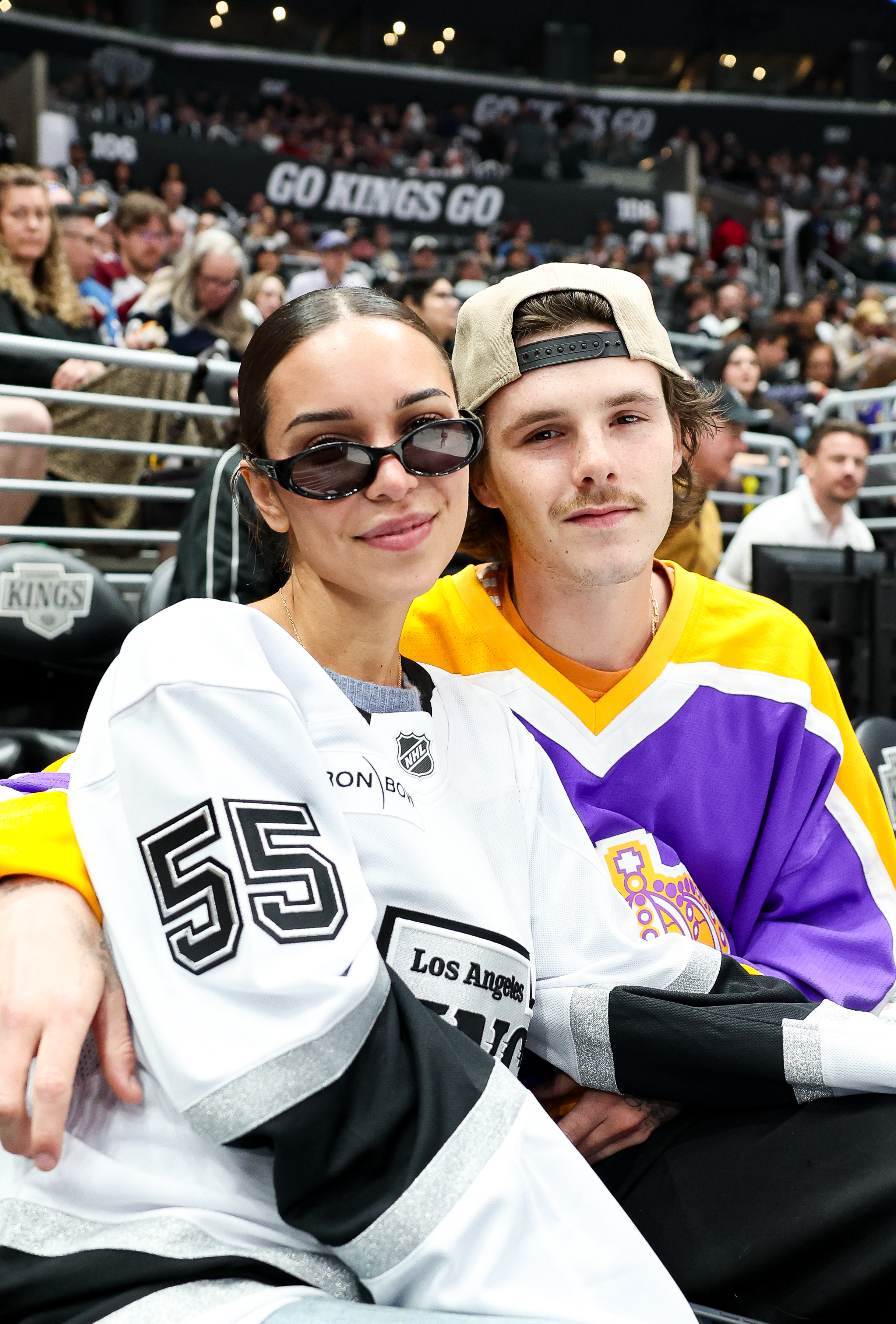 Jackie Apostel and Cruz Beckham posing at a Colorado Avalanche vs. Los Angeles Kings game.