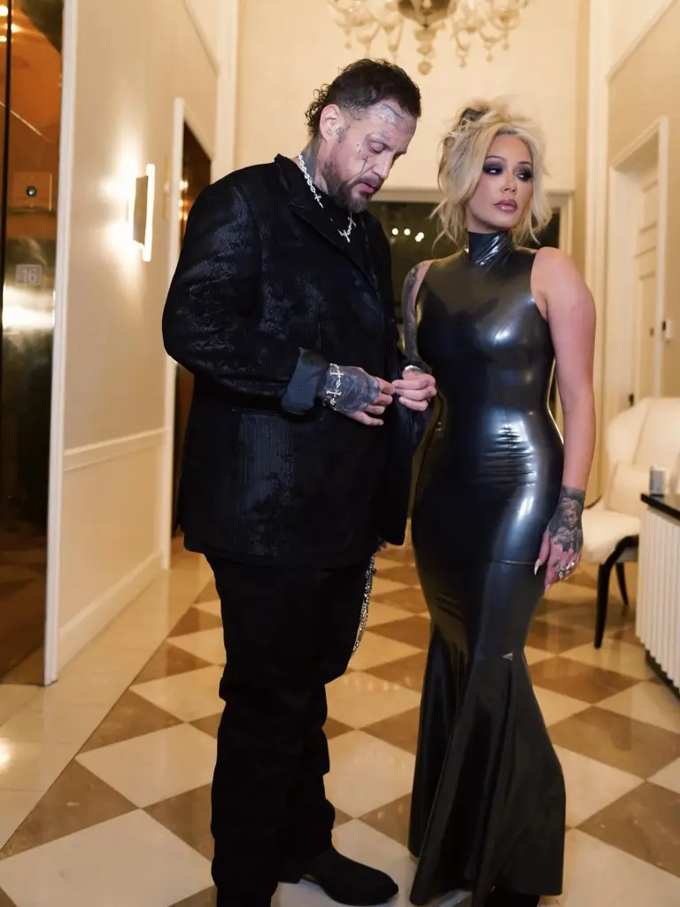 Jelly Roll wearing a black suit and Bunnie XO in a black latex mermaid gown.
