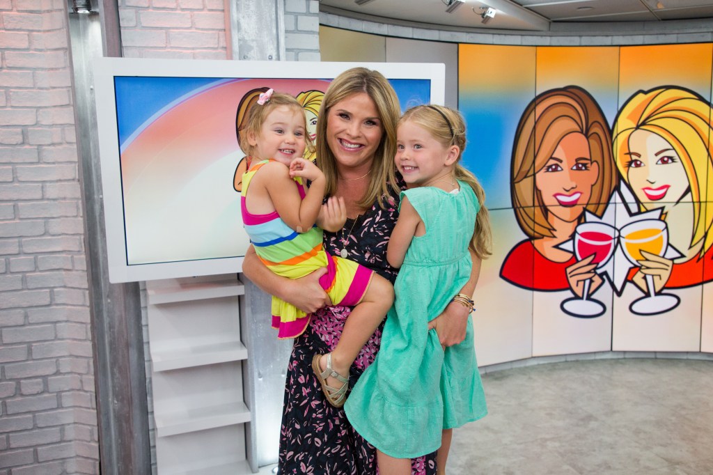 Jenna Bush Hagerm in a floral dress, holding her daughters Poppy Hager, in a multi-colored striped dress, and Mila Hager, in a green dress.