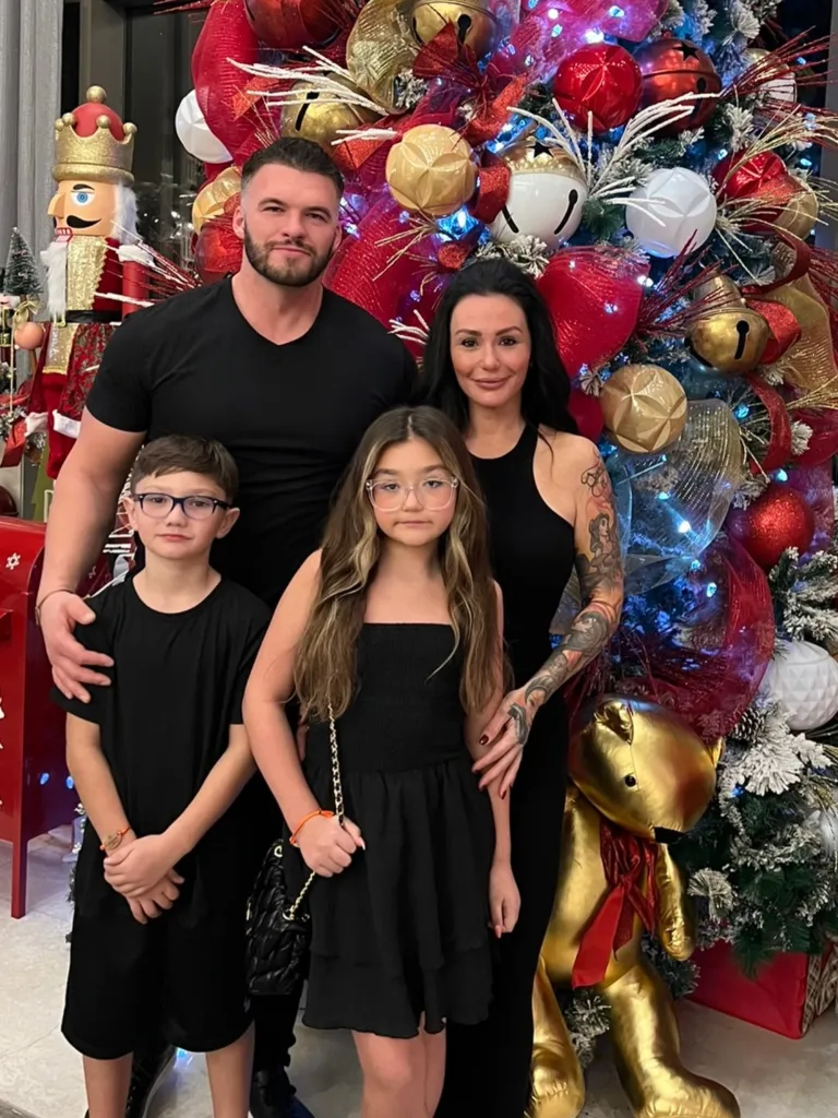 Jenni 'JWoww' Farley and Zack Carpinello pose with children Greyson and Meilani in front of a Christmas tree.