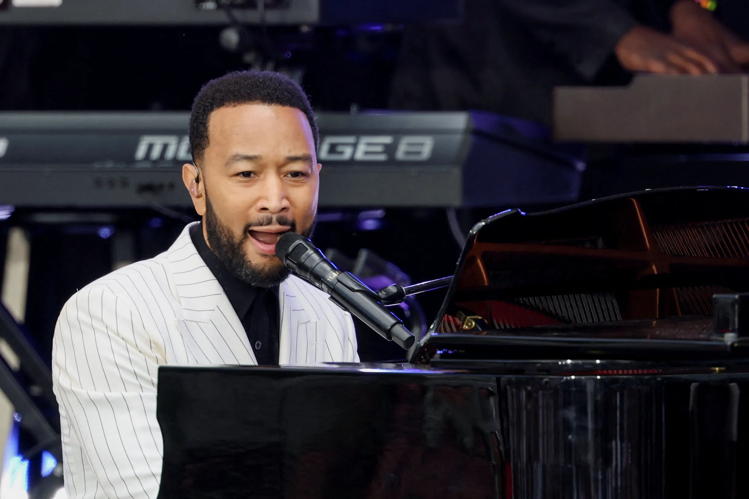 John Legend performs at a piano.