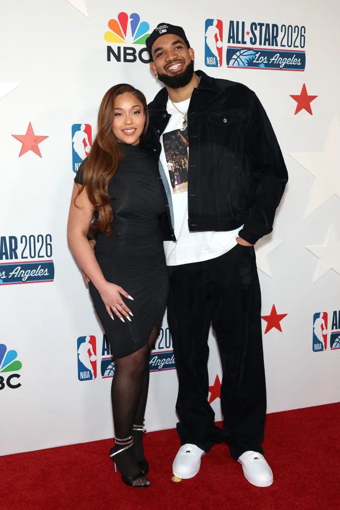 Jordyn Woods and Karl-Anthony Towns posing on the red carpet at the NBA All-Star Legendary Tip-Off Celebration.