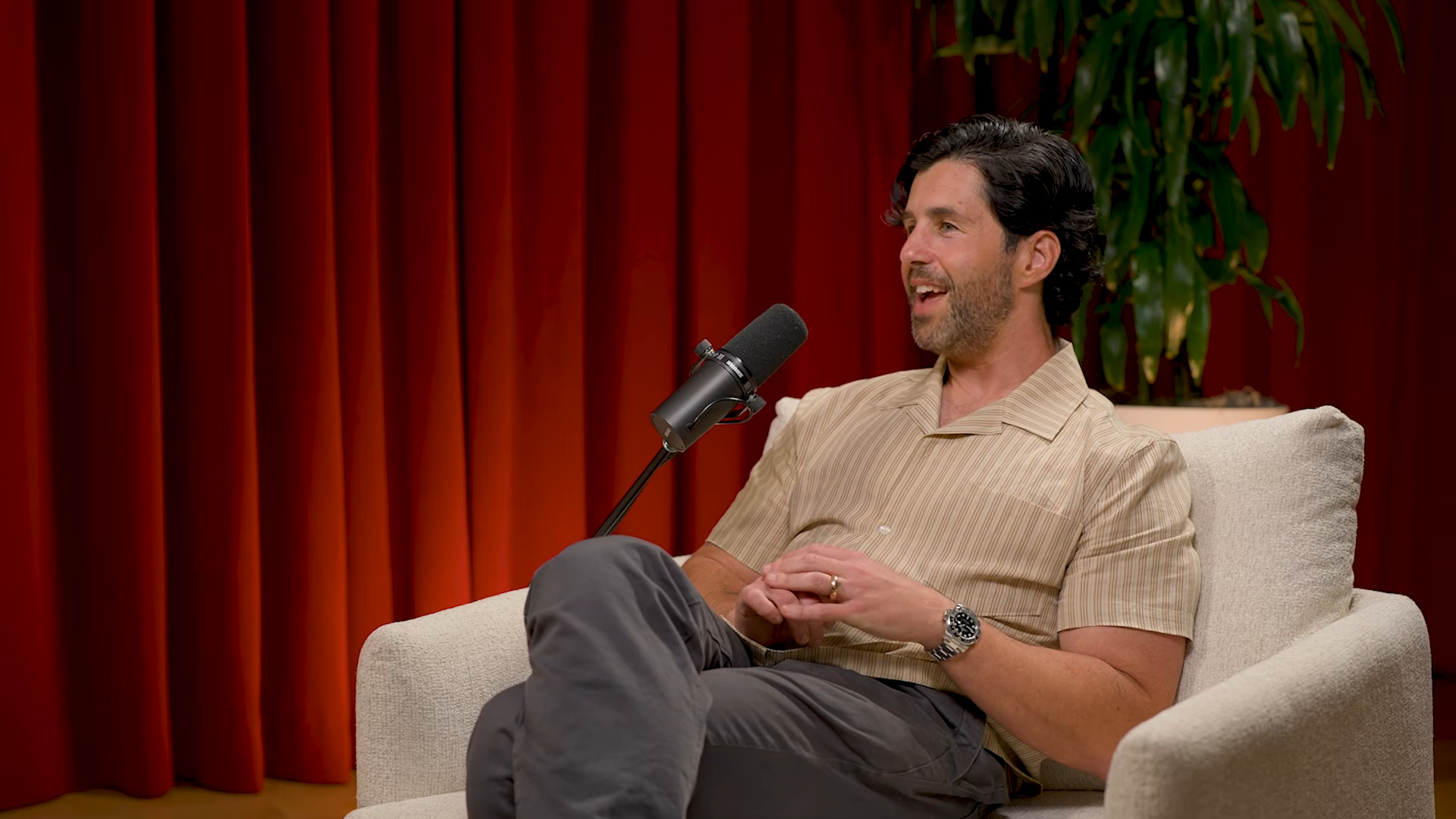Josh Peck speaking into a microphone on the podcast 