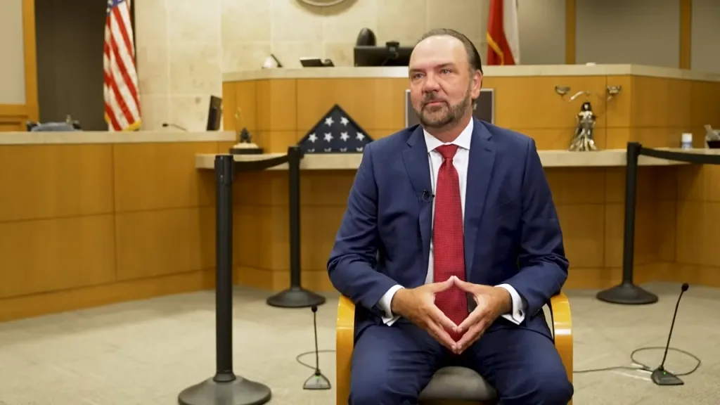 Judge John Roach sitting in a courtroom.