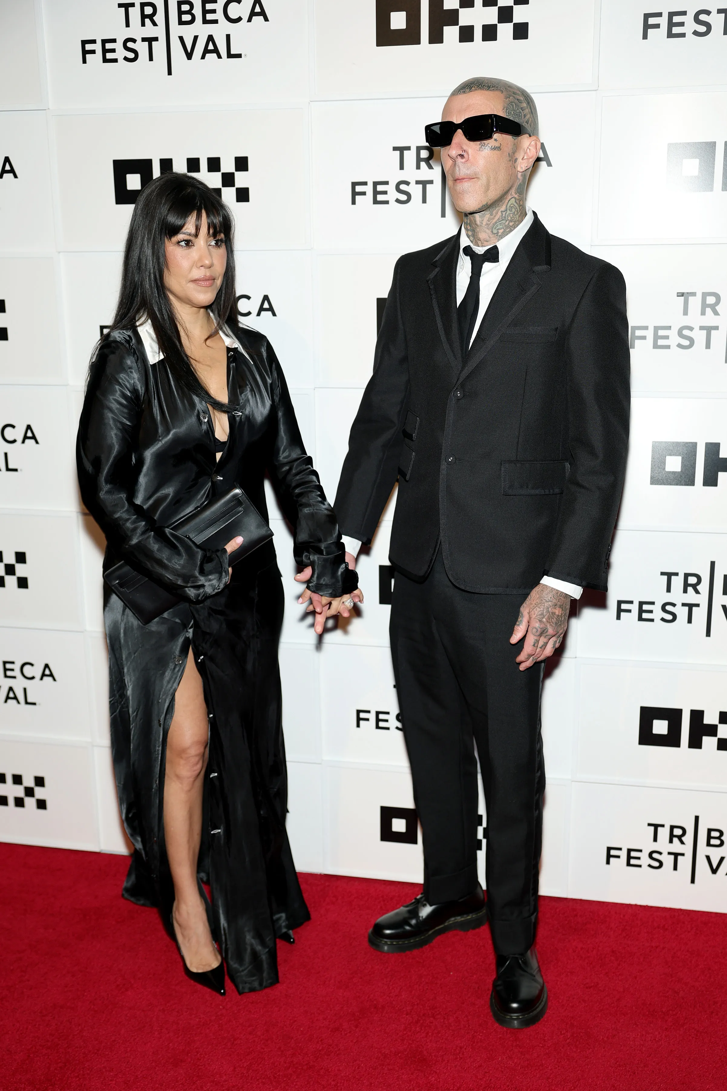 Kourtney Kardashian Barker and Travis Barker holding hands at the