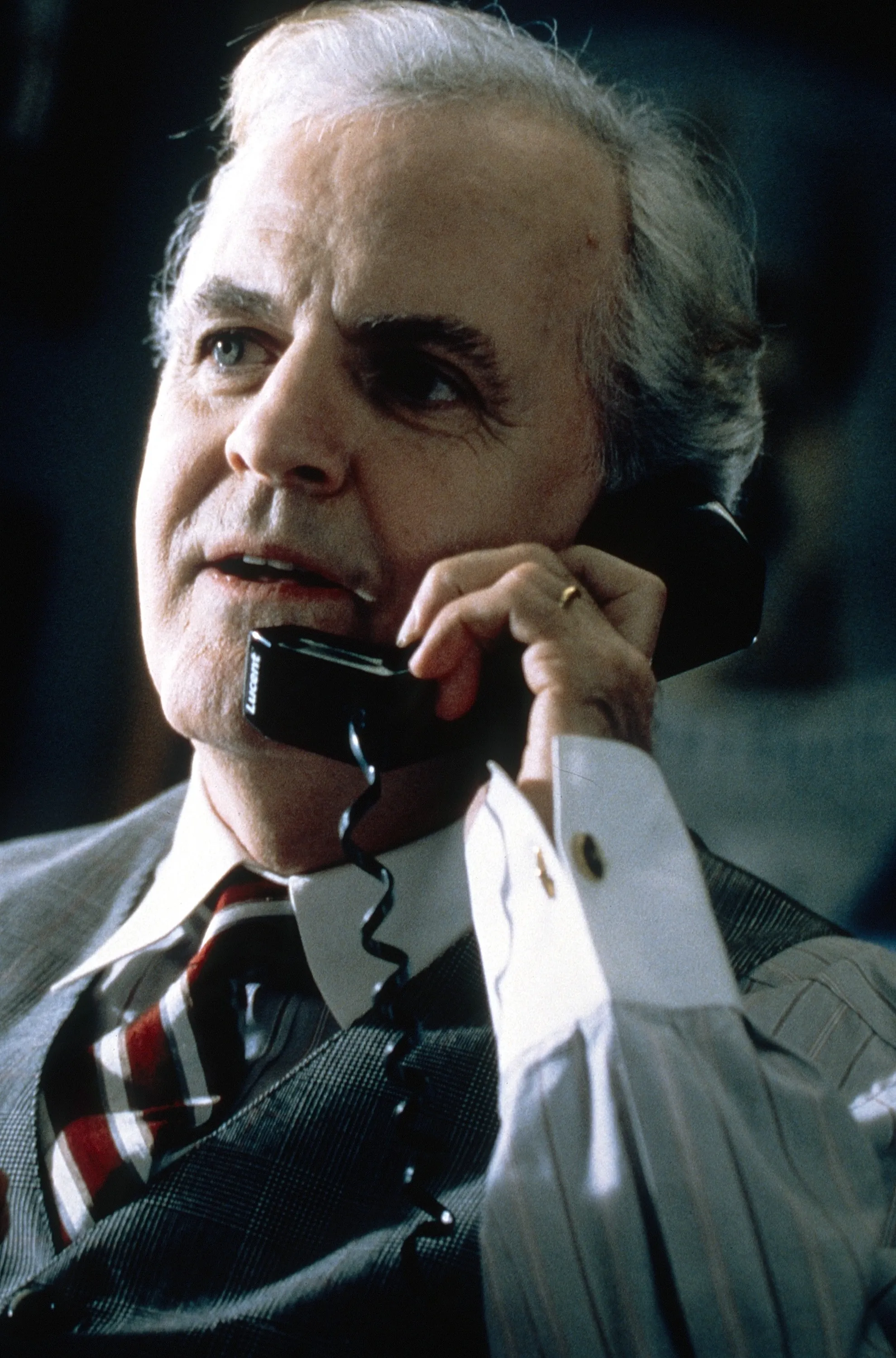James Handy in a suit and tie, holding a telephone to his ear in a headshot from the movie K-911.