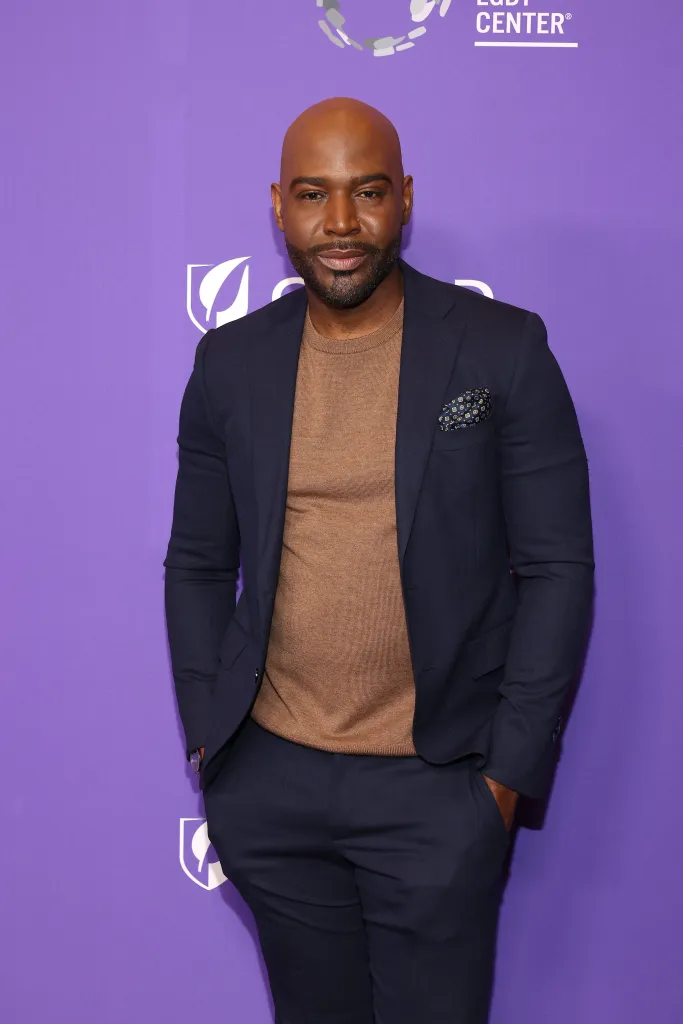 Karamo Brown poses against a purple background at the Los Angeles LGBT Center Gala.