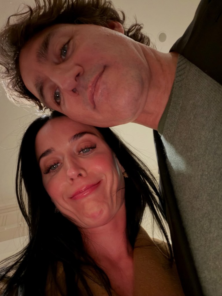 Katy Perry and Justin Trudeau posing together, looking down at the camera.