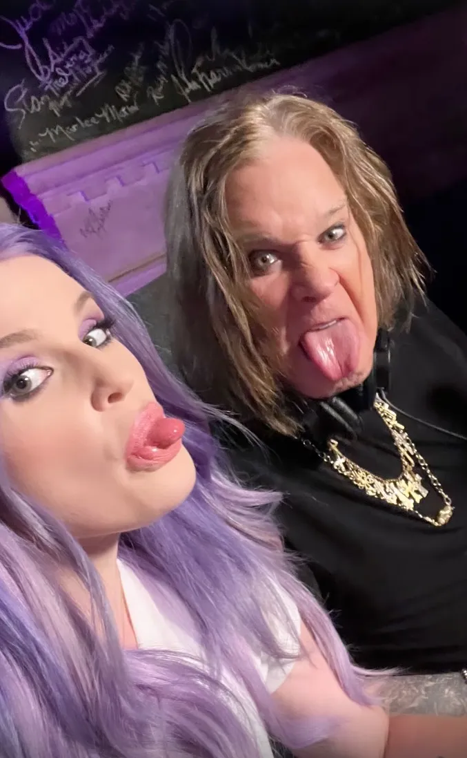 Kelly Osbourne and Ozzy Osbourne make funny faces with their tongues sticking out.