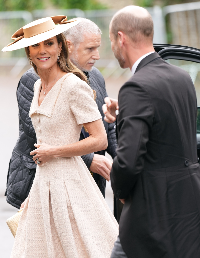 Catherine, Princess of Wales, smiling while wearing a cream dress and a wide-brimmed hat.