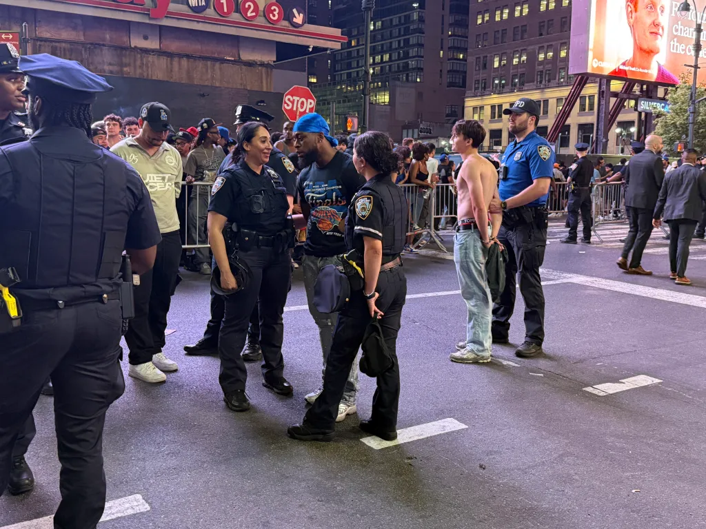 Police officers arresting a shirtless man in handcuffs near Madison Square Garden.