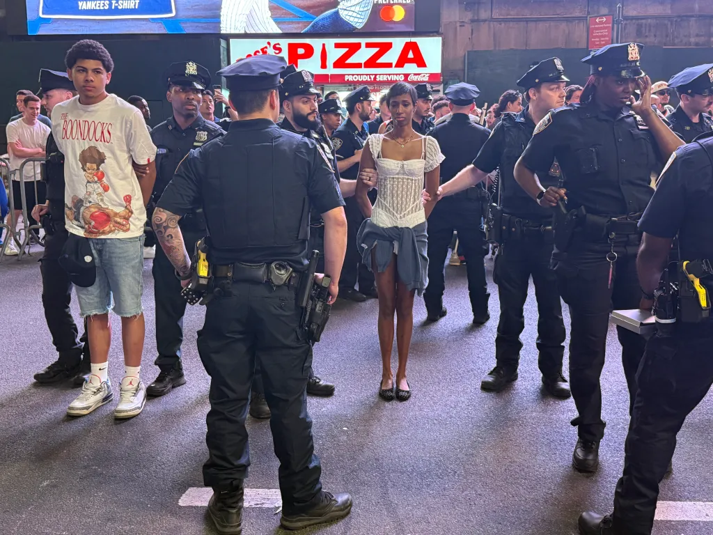 Two people being arrested by police officers near Madison Square Garden.