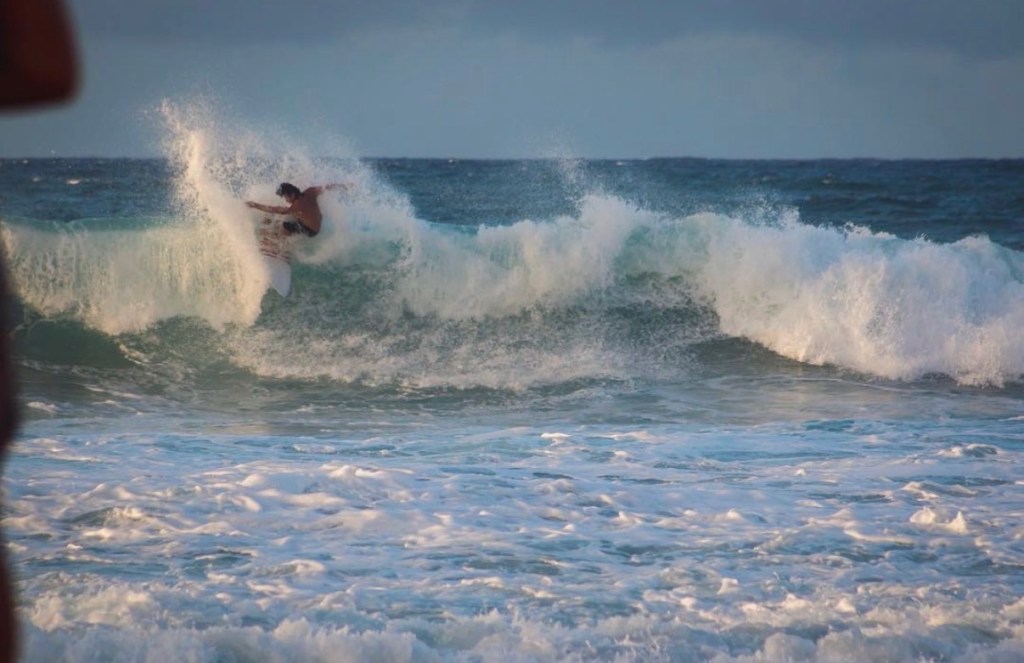 Koa Smith surfing on a large wave.