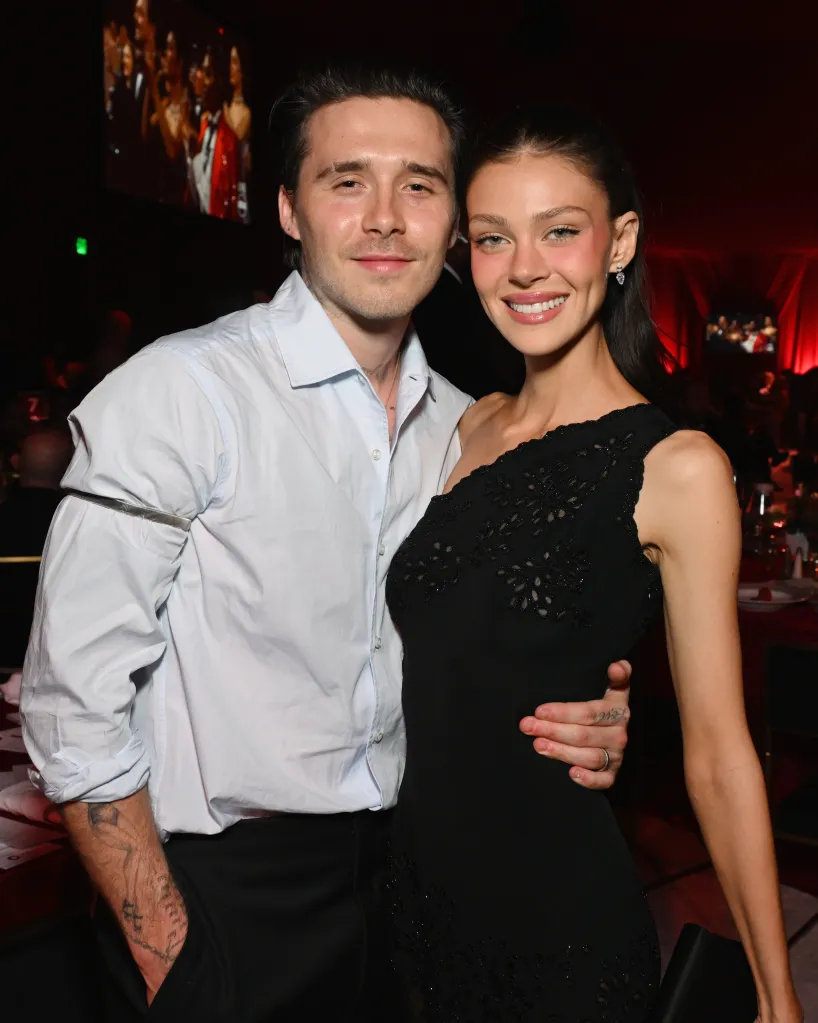 Brooklyn Peltz Beckham in a light blue shirt and Nicola Peltz Beckham in a black one-shoulder dress pose for a picture.