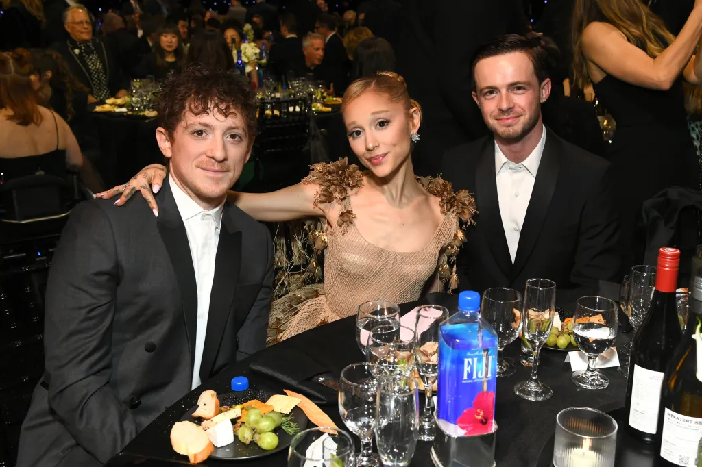 Ethan Slater, Ariana Grande, and a guest posing for a photo at a table during the 30th Critics Choice Awards.